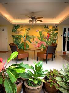 een kamer met een tafel, stoelen en planten bij Salin Home Hotel Ramkhamhaeng in Bangkok