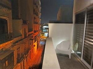 a white chair sitting on the side of a building at Seven in Sliema