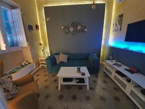 a living room with a blue couch and a table at Seven in Sliema