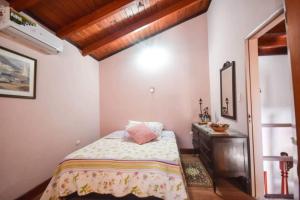 1 dormitorio con 1 cama con tocador y espejo en Familia Luchetti en La Falda