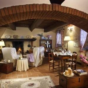 a living room with a table and a fireplace at Salvia e Rosmarino in Camaiore