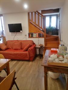 a living room with a red couch and a staircase at Bella Vigezzo in Craveggia