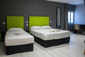 two beds in a room with green walls at La Source in Porcieu-Amblagnieu