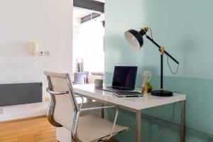 a desk with a laptop and a lamp on it at The Works - Central Manchester Apartment - 2 Parking Spaces in Manchester
