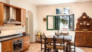 Vilassar de Dalt的住宿－Casa Can Roura，厨房配有桌椅和窗户。