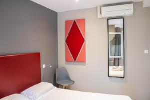 sypialnia z czerwonym łóżkiem i lustrem w obiekcie La Source w mieście Porcieu-Amblagnieu