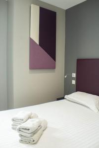 Un dormitorio con una cama con toallas blancas. en La Source, en Porcieu-Amblagnieu