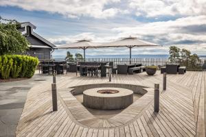 a patio with tables and chairs and umbrellas at Quality Hotel Leangkollen in Asker