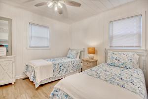 マートルビーチにあるLovely Beach Bungalowのベッド2台と天井ファン付きの寝室