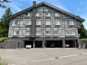 un grand bâtiment avec des voitures garées devant lui dans l'établissement Koguriyama Sanso - Vacation STAY 16071v, à Minami Uonuma