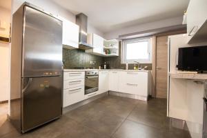 una cucina con frigorifero in acciaio inossidabile e mobili bianchi di 2-bedroom appartment in center a Nicosia
