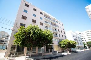un alto edificio bianco con alberi di fronte di 2-bedroom appartment in center a Nicosia