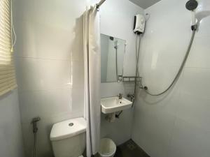 biała łazienka z toaletą i umywalką w obiekcie Hilltop Cabins (Calatagan, Batangas) w mieście Calatagan