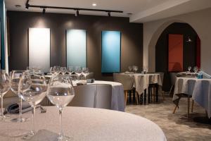 a dining room with tables with wine glasses at La Source in Porcieu-Amblagnieu