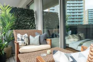 a patio with a chair and a table on a balcony at The Works - Central Manchester Apartment - 2 Parking Spaces in Manchester