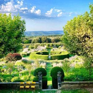 a garden with chairs in the middle of it at Le Pavillon de Galon in Cucuron