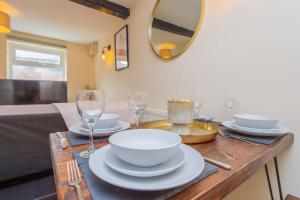 a table with plates and glasses and a mirror at Coton Hill Shrewsbury Cottage in Shrewsbury