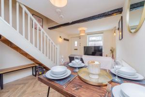 a dining room with a table and a staircase at Coton Hill Shrewsbury Cottage in Shrewsbury