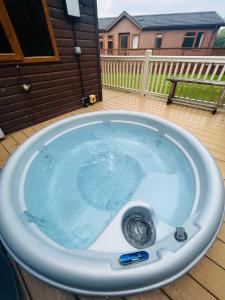 eine Whirlpool-Badewanne auf einer Terrasse im Hinterhof in der Unterkunft Hunters Lodge With Hot Tub in Malton