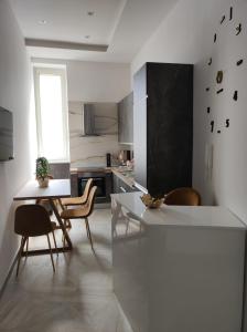 a kitchen with a table and chairs and a table and a window at Twin Towers Naples Luxury in Naples