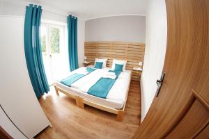 1 dormitorio con 1 cama con cortinas azules en Dom Gościnny Pod Akacjami, en Zbąszyń