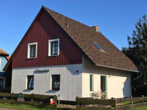 a red and white house with a red roof at TROLLHUS - Großes familienfreundliches Ferienhaus in Born