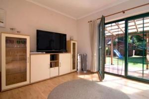 a living room with a television and a sliding glass door at TROLLHUS - Großes familienfreundliches Ferienhaus in Born