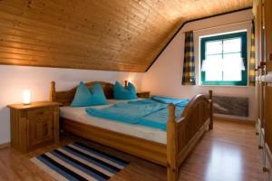 a bedroom with a large bed with blue pillows at TROLLHUS - Großes familienfreundliches Ferienhaus in Born