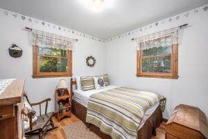 a bedroom with a bed and two windows at Shady Pines in Thompsonville