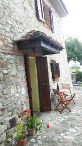 un edificio de piedra con una puerta de madera y un banco en Cottage La Spagna, en Pistoia
