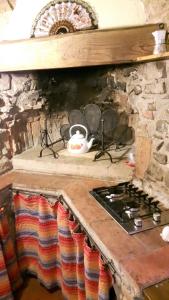 cocina con fogones y pared de piedra en Cottage La Spagna, en Pistoia