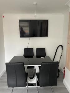 a table with chairs and a television on a wall at Alder en-suite self caring private shower 2 in Southampton