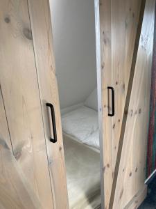 einen Schrank mit Holztüren und einem Bett darin in der Unterkunft Urban Nature13 in Grömitz