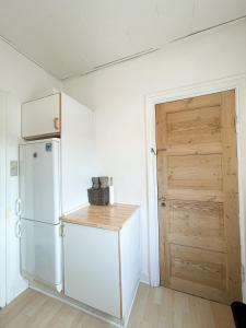 een keuken met een witte koelkast en een houten deur bij Finlandsgade 18 2th ID 047 in Esbjerg