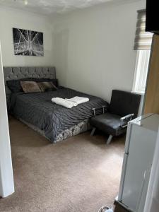 a bedroom with a bed and a chair at Alder en-suite self caring private shower 2 in Southampton