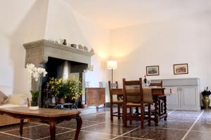 een woonkamer met een tafel en een open haard bij Il Salotto di Berentano in San Casciano in Val di Pesa