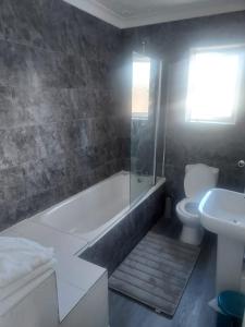 a bathroom with a tub and a toilet and a sink at Alder en-suite self caring private shower 2 in Southampton