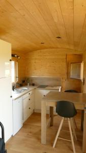 cocina con techo de madera y mesa de madera en Rigoulotte, en Le Val-dʼAjol