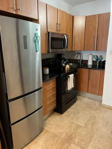 a kitchen with wooden cabinets and a stainless steel refrigerator at KASA Roof Top 6 1 bed 1 bath for 2 Guests AMAZING Views Old San Juan in San Juan