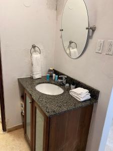 ein Bad mit einem Waschbecken und einem Spiegel in der Unterkunft KASA Roof Top 6 1 bed 1 bath for 2 Guests AMAZING Views Old San Juan in San Juan