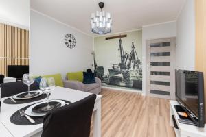a living room with a dining table and a television at Seaview Apartment Gdańsk Przymorze by Renters in Gdańsk