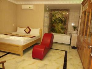 - une chambre avec un lit, une chaise et une baignoire dans l'établissement Amor Hotel, à Hô-Chi-Minh-Ville