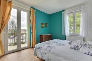 1 dormitorio con paredes azules, 1 cama y ventana en "Urbaine Cosy" Elégance, confort et détente en Alsace "Les Péri-Urbaines", en Riedisheim