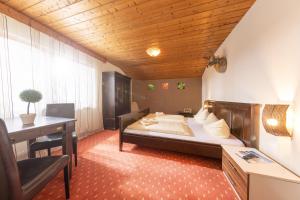 a bedroom with a bed and a desk and a table at T3 Pension Wald am Arlberg in Wald am Arlberg