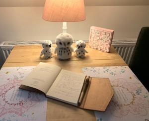 an open book on a table with stuffed animals and a lamp at B&B De Drie Uiltjes in Epe