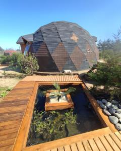 a koi pond in front of a dome at La Tribu Ecolodge y Camping in Algarrobo