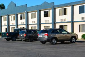 tres autos estacionados en un estacionamiento frente a un edificio en Buckeye Inn near OSU Medical Center, Columbus OH I-71 By OYO, en Columbus