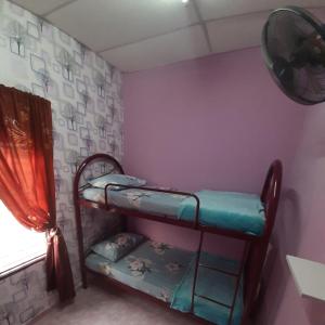 a room with two bunk beds in a room at HAIDA'S HOMESTAY Seri Iskandar, Perak in Seri Iskandar