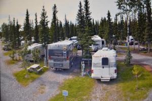 a group of recreational vehicles parked in a parking lot at Tok RV Village and Cabins in Tok