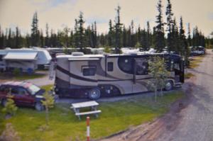 an rv parked in a parking lot with a picnic table at Tok RV Village and Cabins in Tok